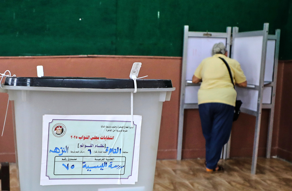 An Egyptian woman casts her ballot during the second phase of parliamentary elections in Cairo, Egypt, Monday, Nov. 24, 2025. (AP Photo/Khaled Elfiqi)