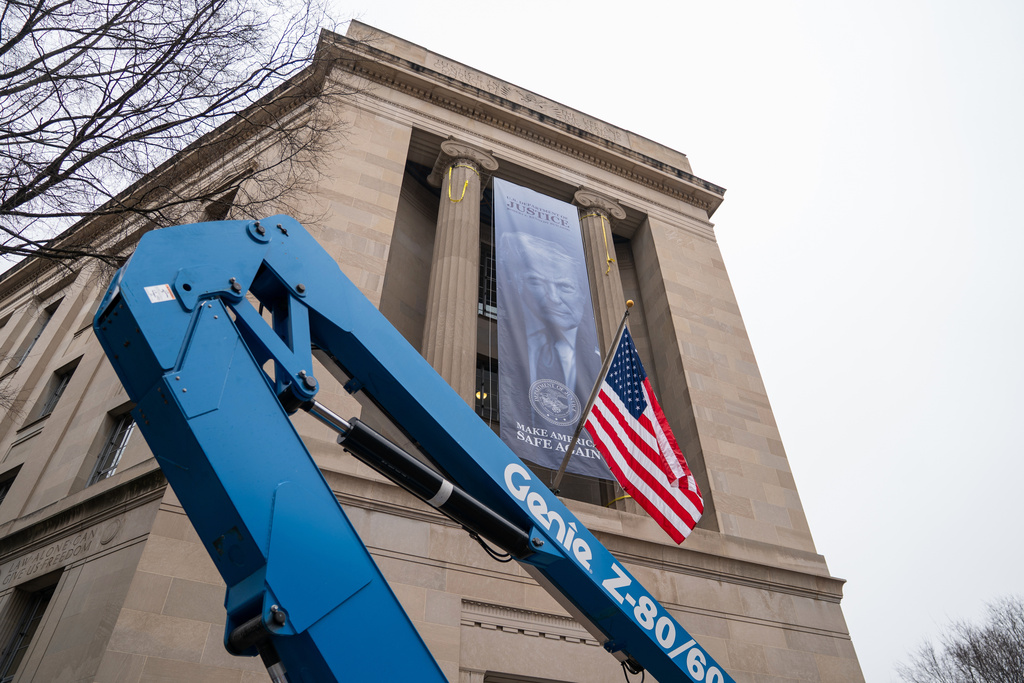 A banner showing President Donald Trump is hung from the Department of Justice, Thursday, Feb. 19, 2026, in Washington. (AP Photo/Allison Robbert)