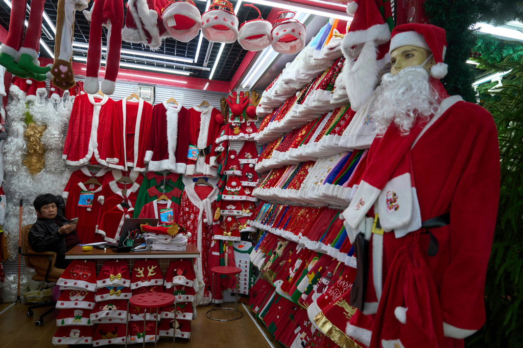 FILE - A vendor waits for customers near Santa costumes for sale at the Yiwu International Trade Market in Yiwu, eastern China's Zhejiang province on April 10, 2025. (AP Photo/Ng Han Guan, File)