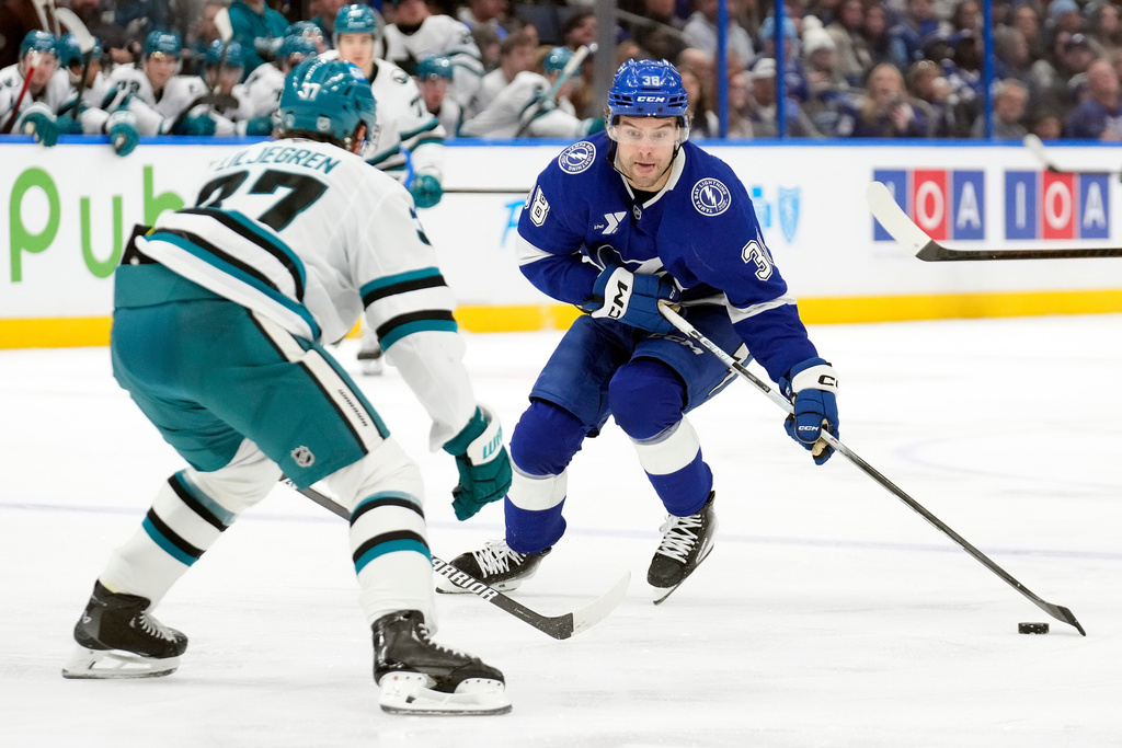 Tampa Bay Lightning left wing Brandon Hagel (38) works around San Jose Sharks defenseman Timothy Liljegren (37) during the second period of an NHL hockey game Tuesday, Jan. 20, 2026, in Tampa, Fla. (AP Photo/Chris O'Meara)