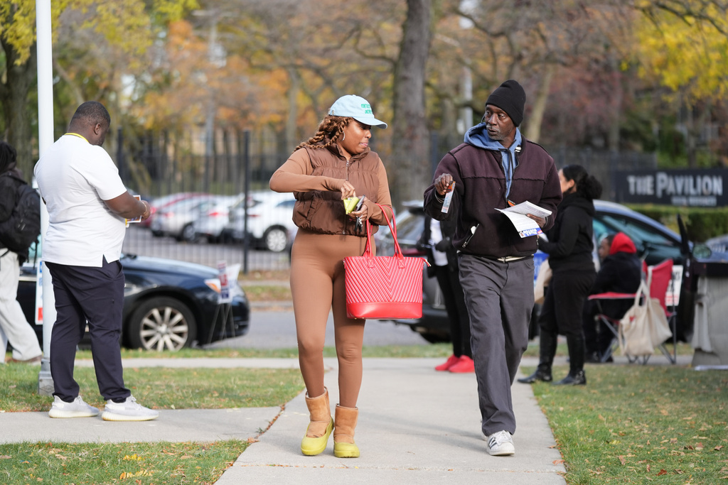 Canvassers talk to voters on their way to vote outside the Horatio Williams Foundation in downtown Detroit, Tuesday, Nov. 4, 2025. (AP Photo/Ryan Sun)
