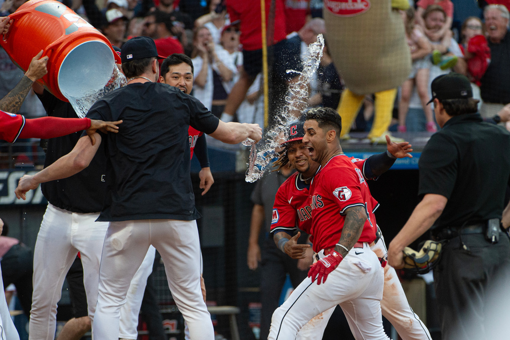 Cleveland Guardians' Brayan Rocchio, center front, is congratulated by Jose Ramirez, center rear, and their teammates after Rocchio's game winning three-run home run off Texas Rangers relief pitcher Jose Corniell at the end of a baseball game, Sunday, Sept. 28, 2025, in Cleveland. (AP Photo/Phil Long)