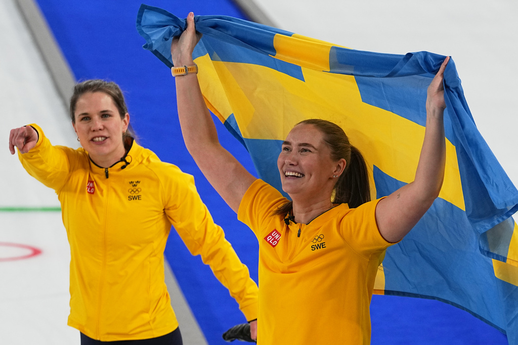 Sweden's Anna Hasselborg, left, and Sara McManus celebrate winning a women's curling gold medal match between Switzerland and Sweden, at the 2026 Winter Olympics, in Cortina d'Ampezzo, Italy, Sunday, Feb. 22, 2026. (AP Photo/Fatima Shbair)