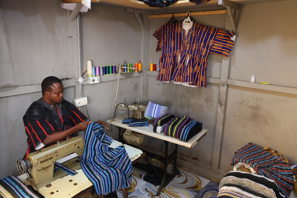 Moses Adibasa, a traditional fugu garment maker, works on in his workshop in Accra, Ghana, Wednesday, Feb. 18, 2026. (AP Photo/Tsraha Yaw)
