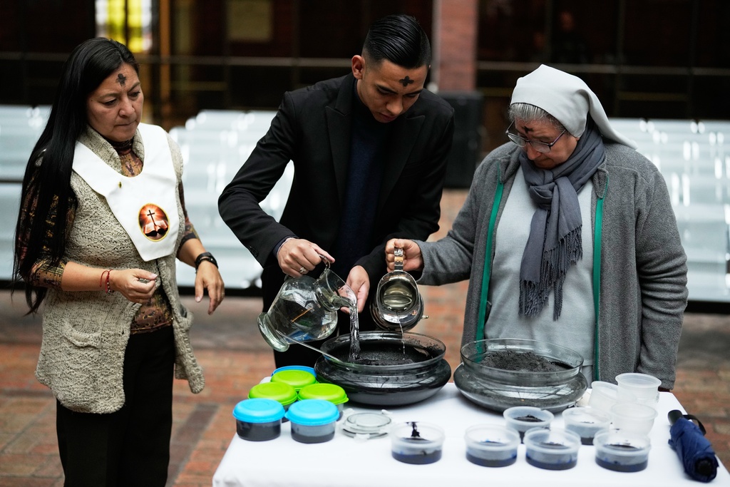 Catholic Sacristan Santiago Moreno, center, Sister Diva Camacho, right, and Lay Minister Yolanda Carrillo prepare ashes that will mark people's foreheads during Ash Wednesday Mass at the Divine Child Church in Bogota, Colombia, Wednesday, Feb. 18, 2026, the start of the Christian season of Lent, a period of penitence and reflection that leads up to Easter. (AP Photo/Fernando Vergara)