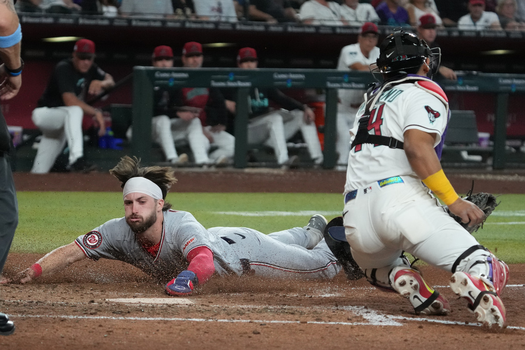 Washington Nationals' Dylan Crews scores a run against the Arizona Diamondbacks on a ball hit by Nasim Nuñez in the ninth inning of a baseball game, Saturday, June 6, 2026, in Phoenix. (AP Photo/Rick Scuteri)