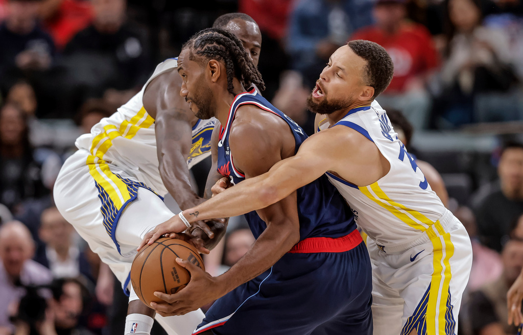 Golden State Warriors' Draymond Green, left, and Stephen Curry (30) defend against Los Angeles Clippers' Kawhi Leonard in the first half of an NBA play-in tournament basketball game in Inglewood, Calif., on Wednesday, April 15, 2026. (Carlos Avila Gonzalez/San Francisco Chronicle via AP)