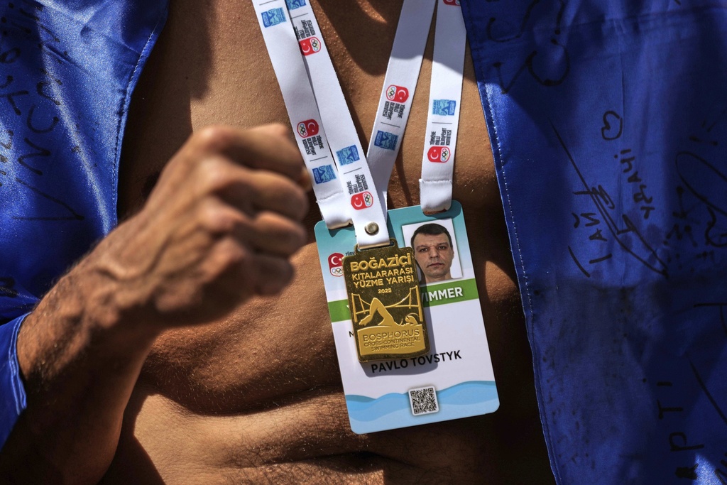 Ukrainian war veteran Pavlo Tovstyk dons a medal for his participation in a 6.5km swimming race across the Bosporus Strait, in Istanbul, Turkey, Sunday, Aug. 24, 2025. (AP Photo/Khalil Hamra)