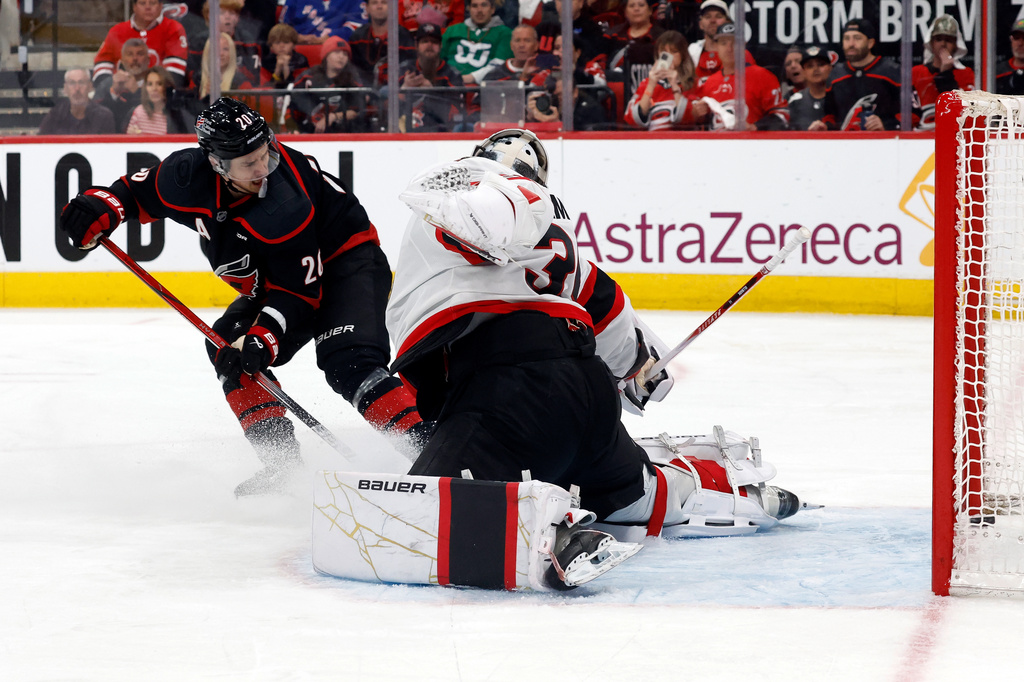 Carolina Hurricanes' Sebastian Aho (20) slips the puck past Ottawa Senators goaltender Linus Ullmark, right, for a goal during the second period of Game 2 of an NHL hockey Stanley Cup first-round playoff series in Raleigh, N.C., Monday, April 20, 2026. (AP Photo/Karl DeBlaker)
