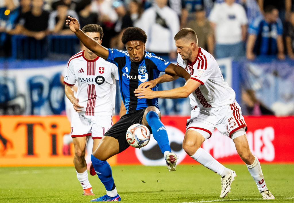 CF Montreal's Owen Graham-Roache, center, is pressured by Toronto FC's Walker Zimmerman, right, and Alonso Coello (14) during second half of an MLS soccer game, in Montreal on Thursday, July 16, 2026. (Christopher Katsarov/The Canadian Press via AP)