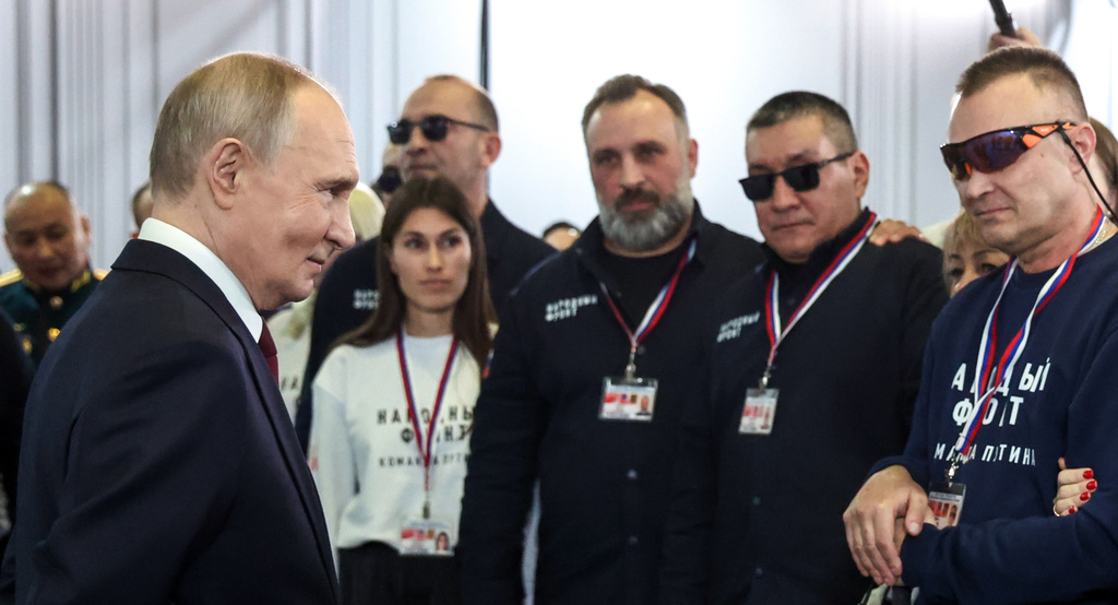 Russian President Vladimir Putin, left, thanks a group of volunteers who worked preparing his call-in show at Gostinny Dvor, in Moscow, on Friday, Dec. 19, 2025. (Alexander Kazakov, Sputnik, Kremlin Pool Photo via AP)