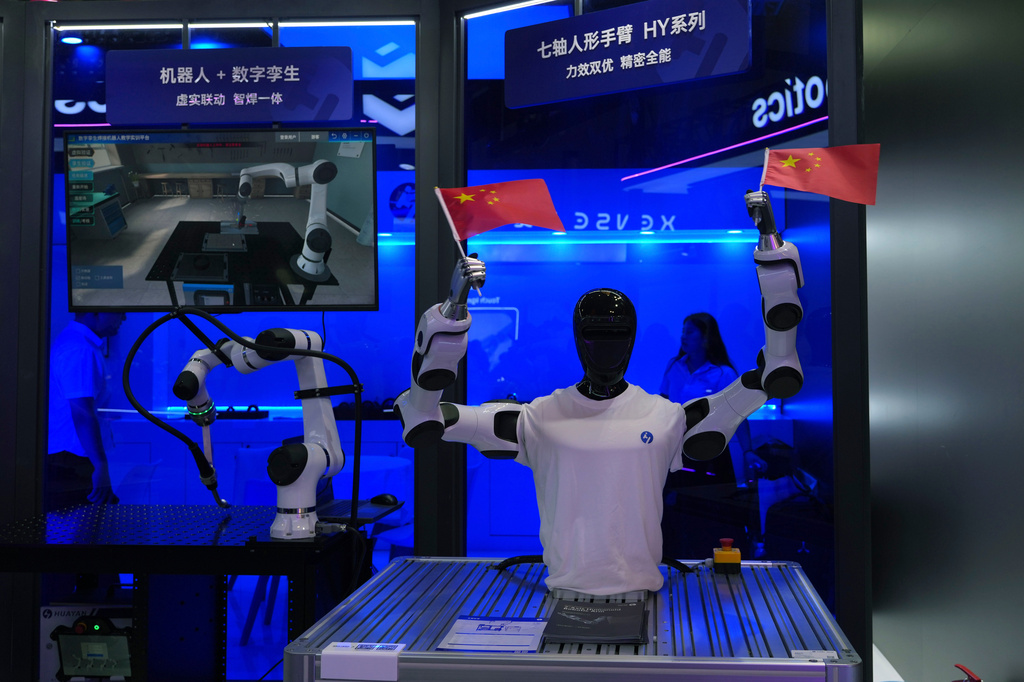 A humanoid robot waves Chinese national flags at the World AI Conference in Shanghai, Saturday, July 18, 2026. (AP Photo/Ng Han Guan)