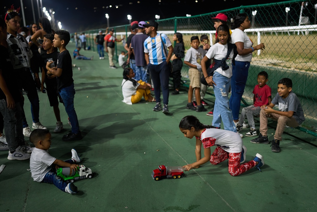 Children play during the 56th Jockey Challenge at the Rinconada racetrack in Caracas, Venezuela, Sunday, Dec. 14, 2025. (AP Photo/Arian Cubillos)