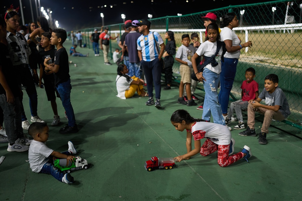Children play during the 56th Jockey Challenge at the Rinconada racetrack in Caracas, Venezuela, Sunday, Dec. 14, 2025. (AP Photo/Ariana Cubillos)