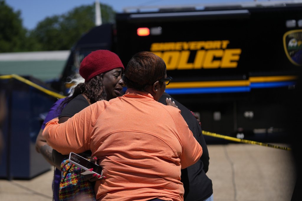 People console each other as they gather at the scene of a mass shooting in Shreveport, La., Sunday, April 19, 2026. (AP Photo/Gerald Herbert)