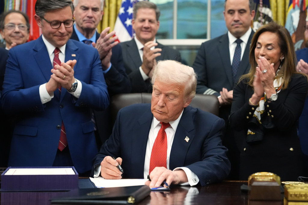 President Donald Trump signs the funding bill to reopen the government, in the Oval Office of the White House, Wednesday, Nov. 12, 2025, in Washington. (AP Photo/Jacquelyn Martin)