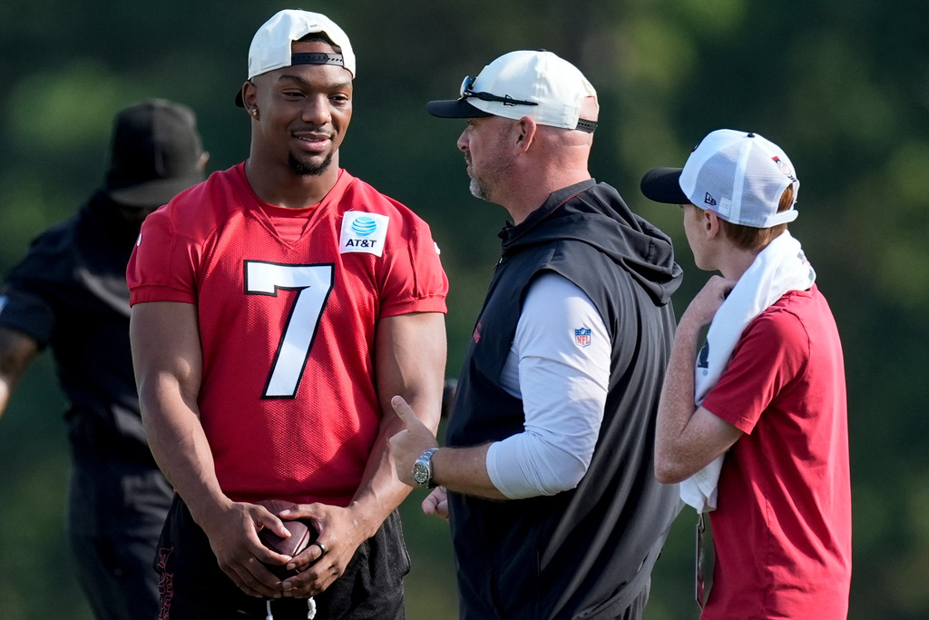 Atlanta Falcons running back Bijan Robinson (7) speak to a coach during a Atlanta Falcons training camp, Monday, Aug. 3, 2026, in Flowery Branch, Ga. (AP Photo/Mike Stewart)