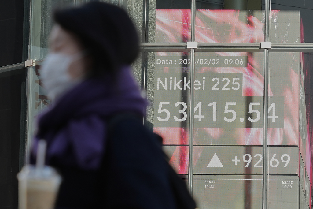 A person walks in front of an electronic stock board showing Japan's Nikkei index at a securities firm Monday, Feb. 2, 2026, in Tokyo. (AP Photo/Eugene Hoshiko)
