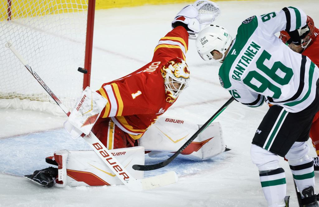 Dallas Stars' Mikko Rantanen, right, has his shot stopped by Calgary Flames goalie Devin Cooley during second period NHL hockey action in Calgary on Saturday, Nov. 22, 2025. (Jeff McIntosh/The Canadian Press via AP)