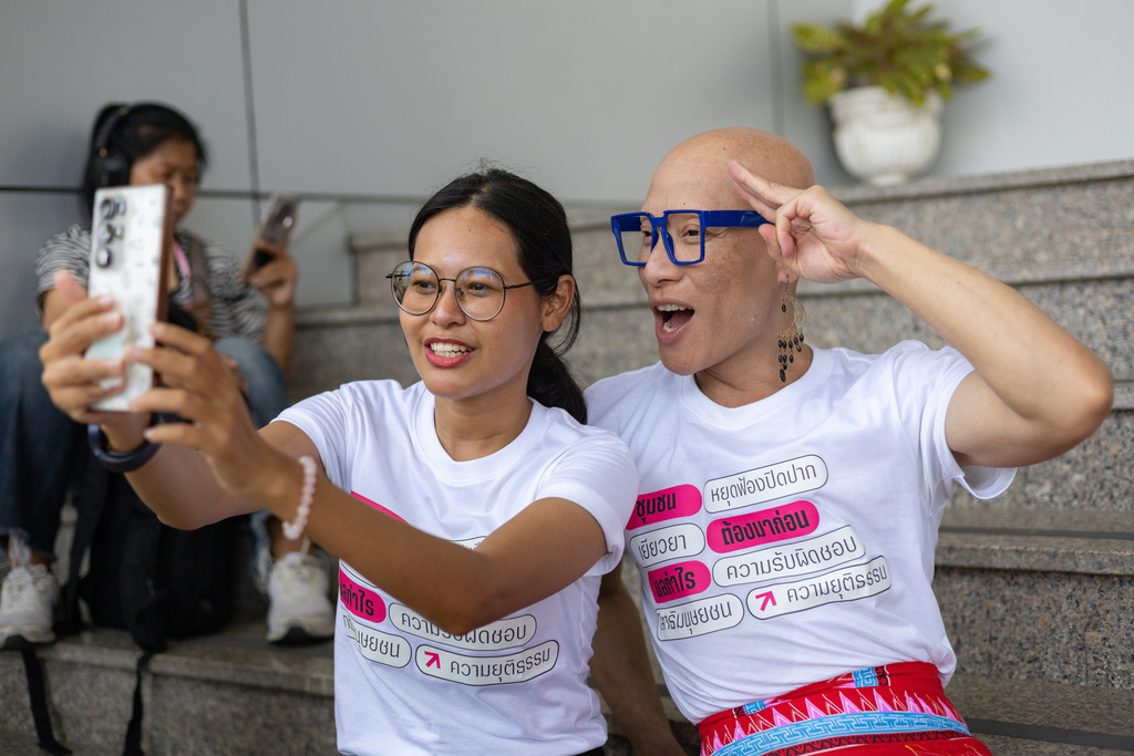 Supporters of a case against Thailand's largest gold mine take a selfie in front of the Bangkok Civil Court in Bangkok, Thailand, on Tuesday, March 24, 2026. (AP Photo/Anton L. Delgado)