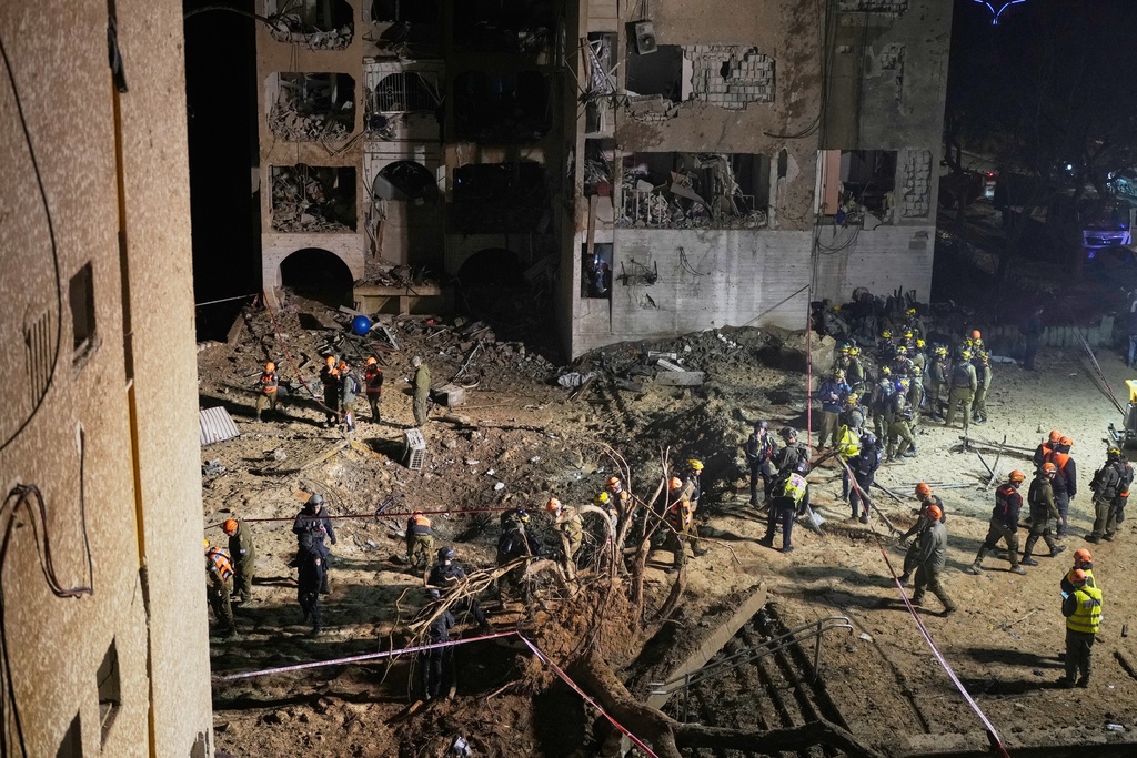 Israeli security forces and rescue teams work at the site struck by an Iranian missile in Arad, southern Israel, Sunday, March 22, 2026. (AP Photo/Ohad Zwigenberg)