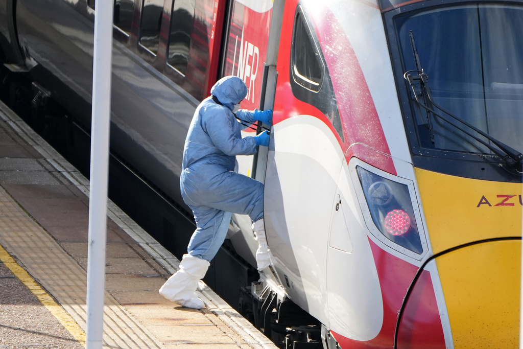 A forensic investigator enters the train after a mass stabbing on a London-bound train in Huntingdon, England, Sunday, Nov. 2, 2025.(AP Photo/Kirsty Wigglesworth)