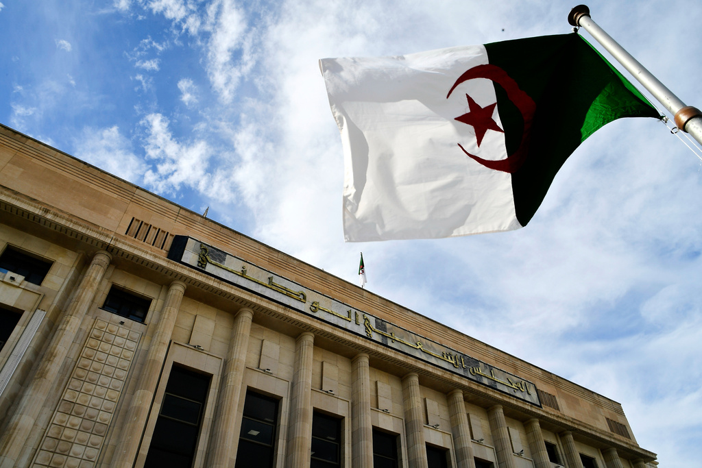 The Algerian flag flies outside the National Assembly as Parliament members vote on a bill seeking to criminalize France's colonisation, considering it a "state crime," and demanding that France issue an official apology and take legal responsibility for its colonial past in addition to compensations, Wednesday, Dec. 24, 2025 at her National Assembly in Algiers. (AP Photo/Fateh Guidoum)