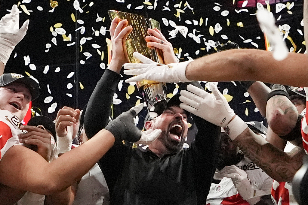FILE - Ohio State head coach Ryan Day celebrates with the trophy after their win over Notre Dame in the College Football Playoff national championship game, Monday, Jan. 20, 2025, in Atlanta. (AP Photo/Brynn Anderson, File)