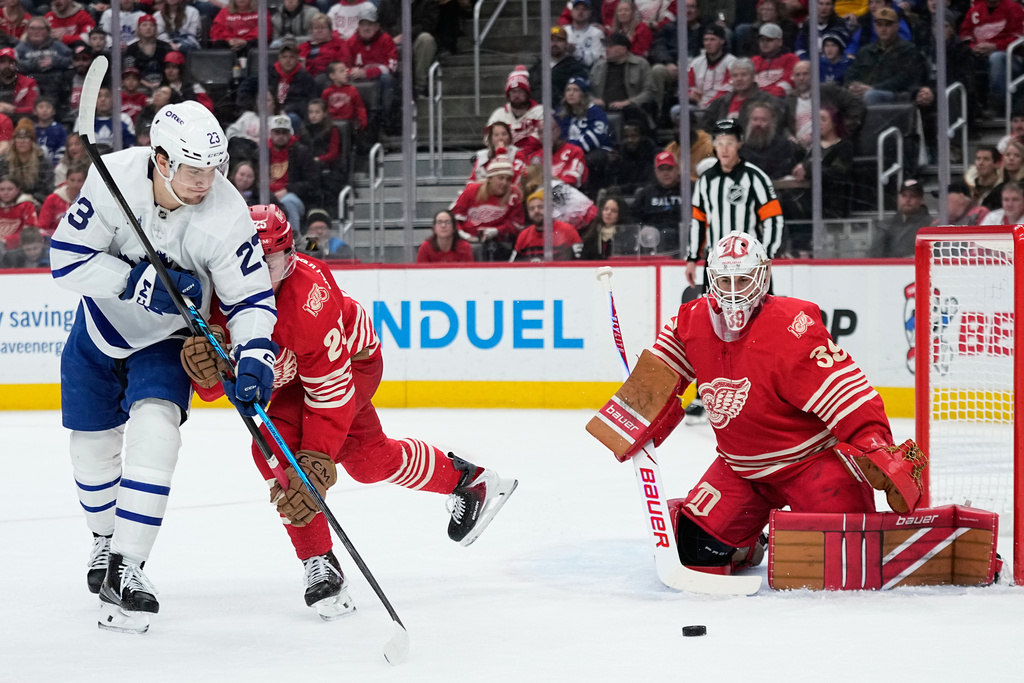 Toronto Maple Leafs left wing Matthew Knies, left, is unable to score against Detroit Red Wings defenseman Jacob Bernard-Docker, center, and goaltender Cam Talbot, right, during the first period of an NHL hockey game Sunday, Dec. 28, 2025, in Detroit. (AP Photo/Ryan Sun)