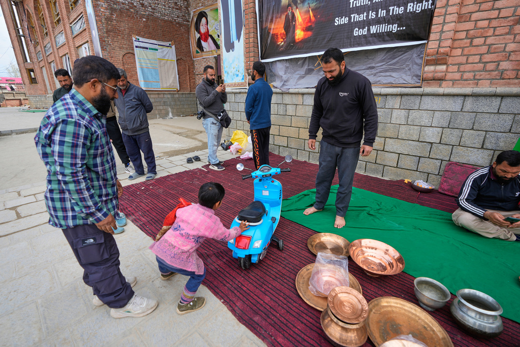 A boy donates his toy scooter during a relief drive for Iran in Budgam, Indian-controlled Kashmir, Monday, March 23, 2026. (AP Photo/Mukhtar Khan)