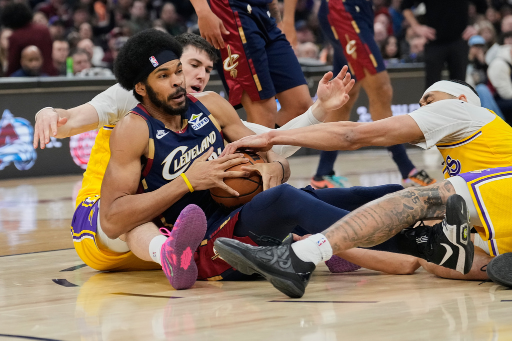 Cleveland Cavaliers center Jarrett Allen, center, fights for control of the ball with Los Angeles Lakers forward Jake LaRavia, left, and center Jaxson Hayes, right, in the first half of an NBA basketball game in Cleveland, Wednesday, Jan. 28, 2026. (AP Photo/Sue Ogrocki)