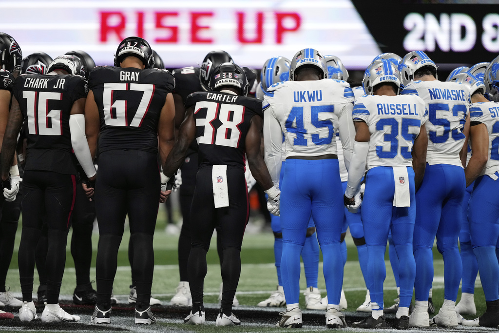 Atlanta Falcons and Detroit Lions players stand on the field hand in hand together after Detroit Lions safety Morice Norris was injured during the second half of an NFL preseason football game Friday, Aug. 8, 2025, in Atlanta. (AP Photo/Brynn Anderson)