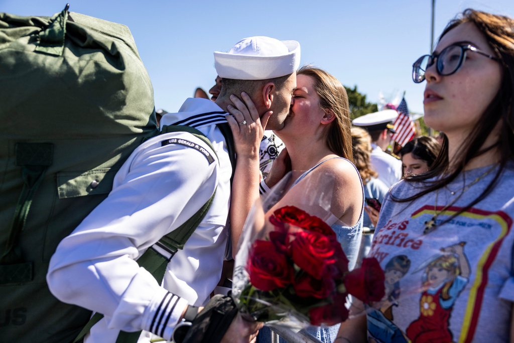 Aviation Support Equipment Technician Second Class Petty Officer Stephen Smith shares a kiss with his wife, Amanda, after disembarking from the USS Gerald R. Ford at Naval Station Norfolk in Norfolk, Va. on Saturday, May 16, 2026, following an 11 month deployment. (Kendall Warner/The Virginian-Pilot via AP)