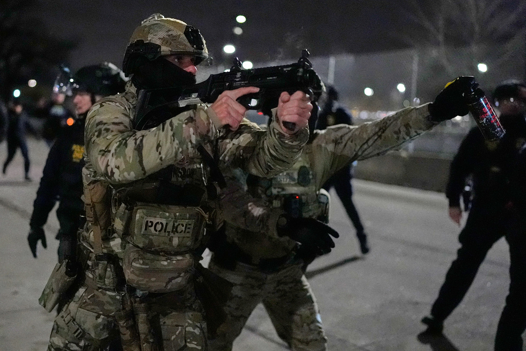 Federal immigration officers confront protesters outside Bishop Henry Whipple Federal Building, Thursday, Jan. 15, 2026, in Minneapolis. (AP Photo/Yuki Iwamura)