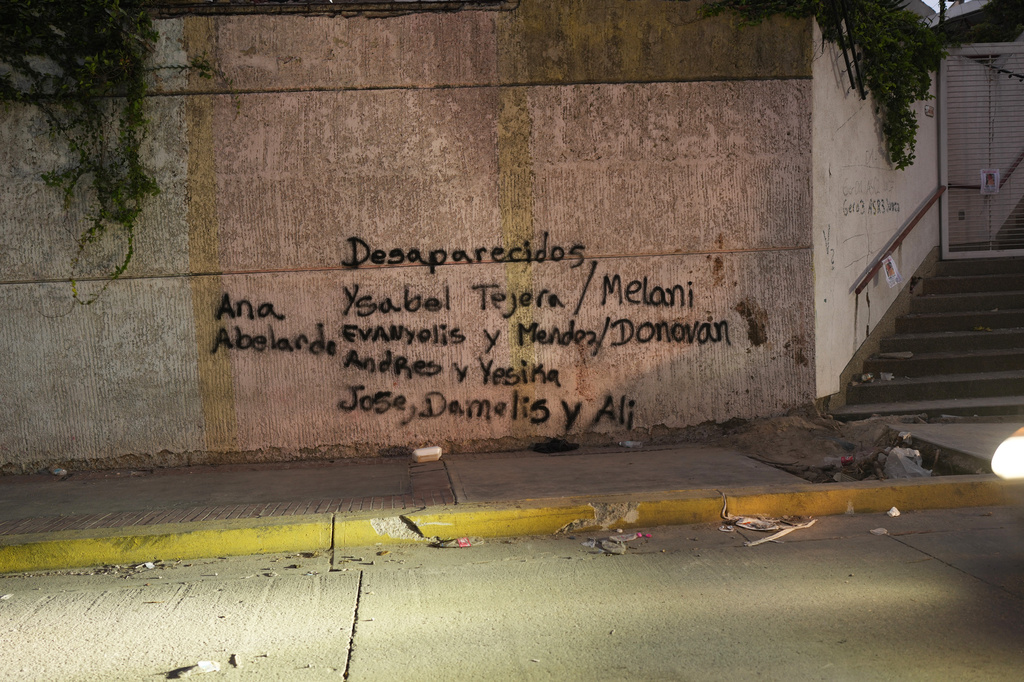 Names of missing people painted by relatives cover the front of a damaged building in La Guaira, Venezuela, three days after earthquakes struck, Saturday, June 27, 2026.. (AP Photo/Matias Delacroix)