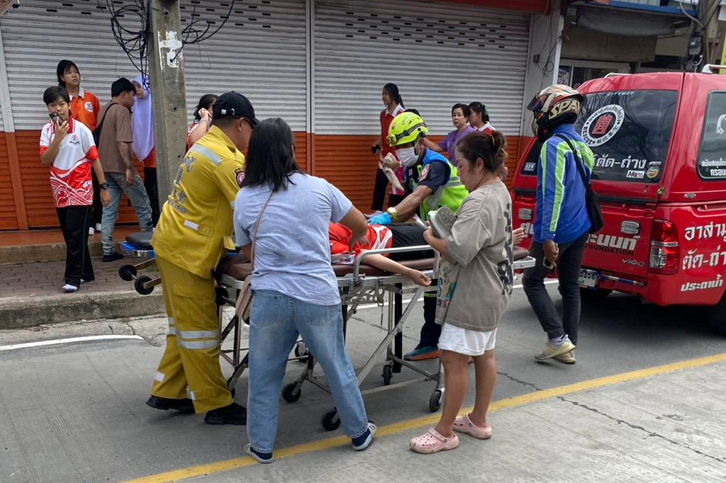 An injured is carried on a stretcher outside a outside a school where deaths and injuries were reported after a shooting in Thailand's Nonthaburi province, Friday, Aug. 7, 2026. (Por Tek Tueng Nonthaburi via AP)