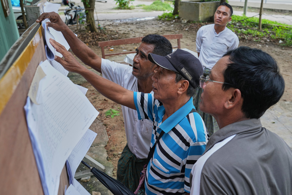 Men check for names on officially published eligible-voter list at a ward administrative office in Naypyitaw, Myanmar, Tuesday, Sept. 30, 2025. (AP Photo/Aung Shine Oo)