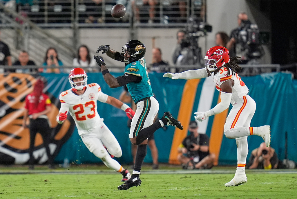 Jacksonville Jaguars wide receiver Dyami Brown (5) can't catch a pass under pressure from Kansas City Chiefs linebackers Drue Tranquill (23) and Nick Bolton (32) during the first half of an NFL football game, Monday, Oct. 6, 2025, in Jacksonville, Fla. (AP Photo/John Raoux)