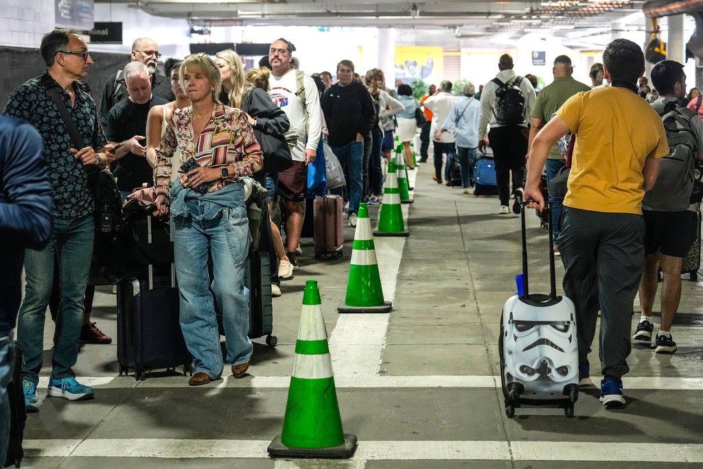 Airline passengers wait outside the terminal in the parking garage in long lines to get through the TSA security screening at William P. Hobby Airport in Houston, Sunday, March 8, 2026. (Brett Coomer/Houston Chronicle via AP)
