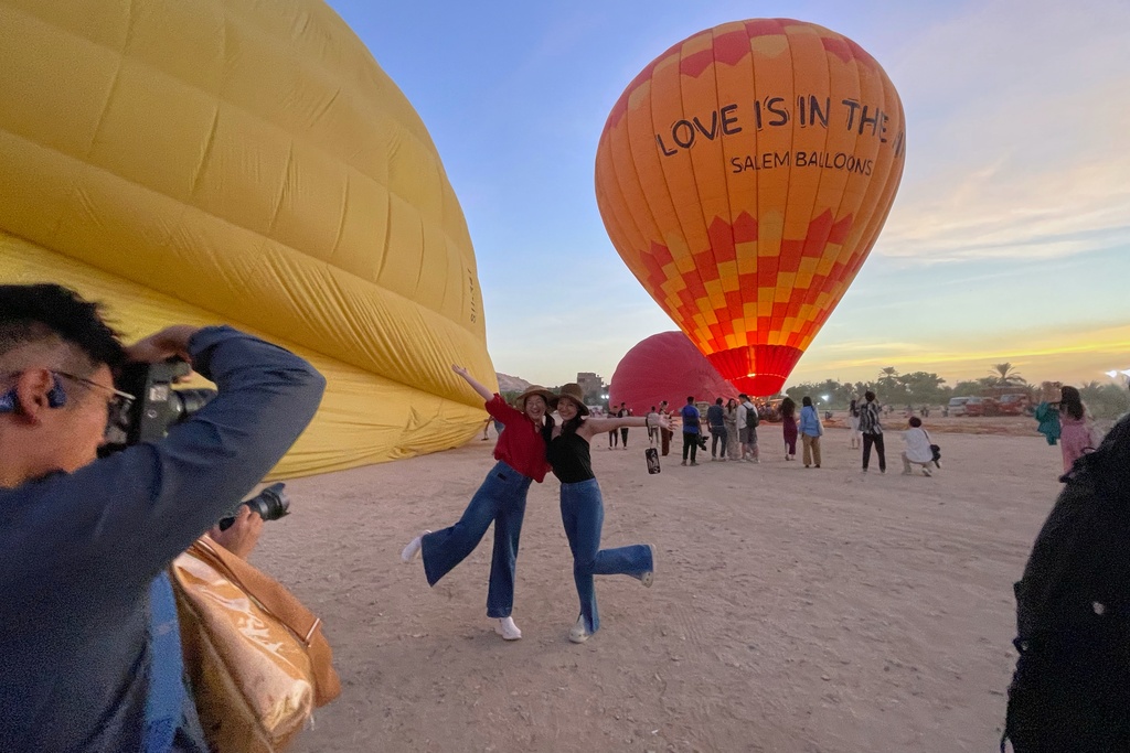 Chinese tourists pose for pictures before their tour on a hot air balloon on the west bank of the Nile River in Luxor, Egypt, Oct. 4, 2025. (AP Photo/Amr Nabil)
