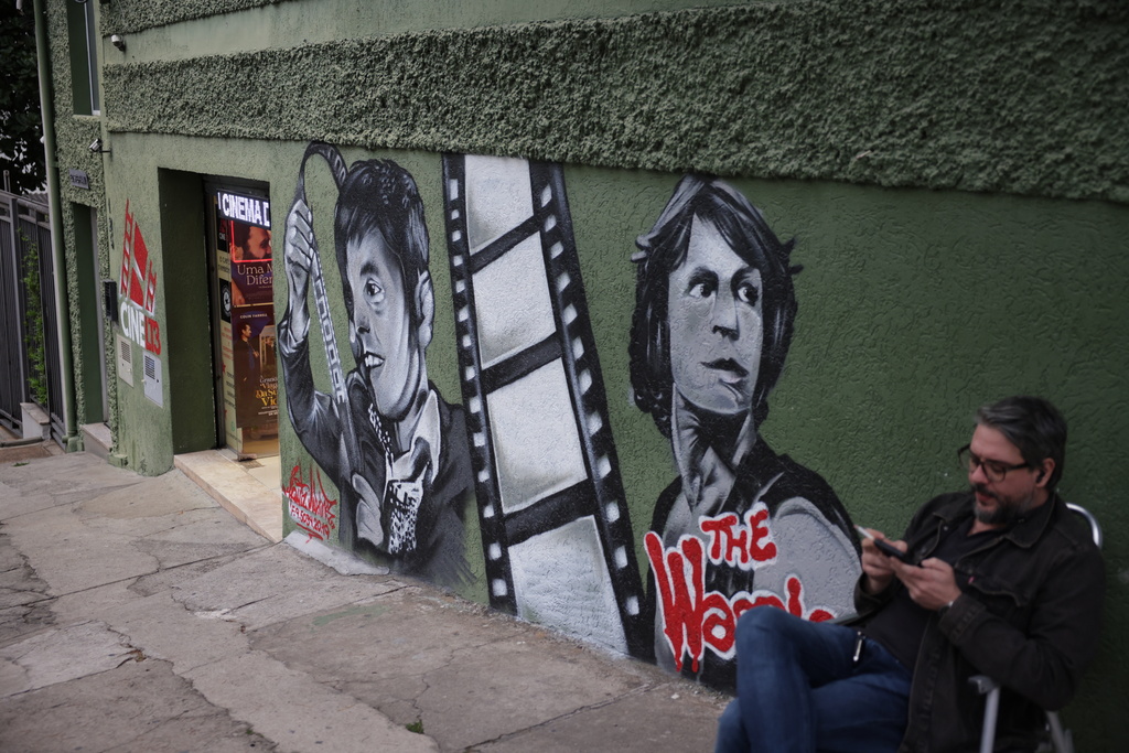 A man sits outside Cine LT3 cinema built in an old parking garage in Sao Paulo, Thursday, Oct. 9, 2025. (AP Photo/Ettore Chiereguini)