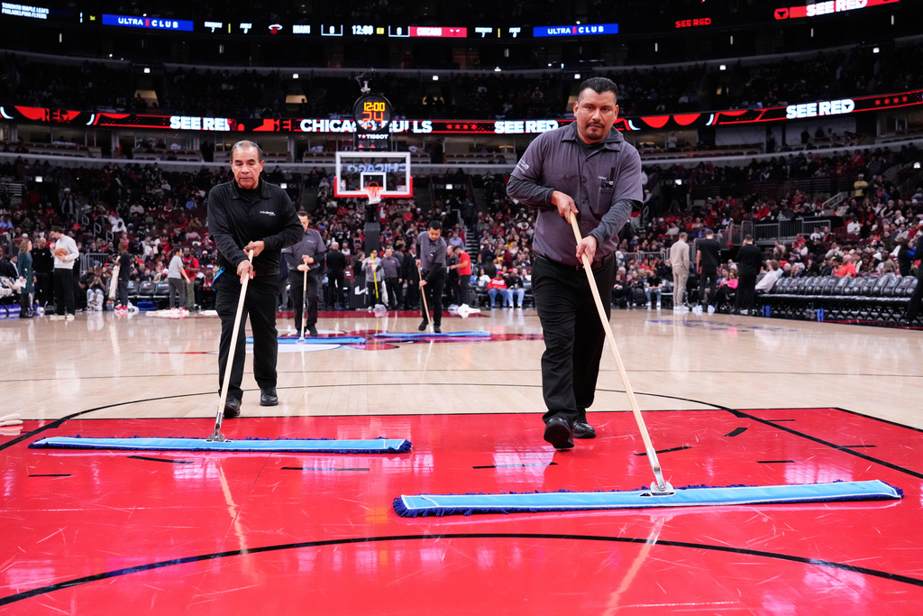 United Center employees try to dry the court before an NBA basketball game between the Miami Heat and the Chicago Bulls in Chicago, Thursday, Jan. 8, 2026. (AP Photo/Nam Y. Huh)