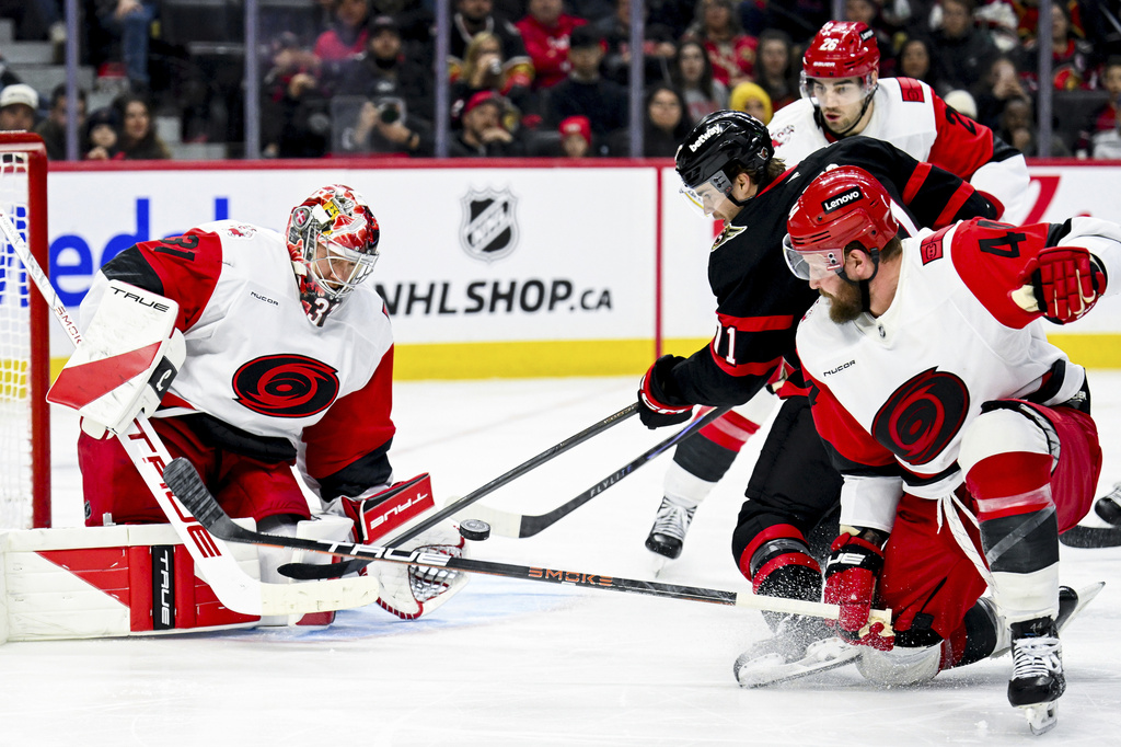 Ottawa Senators' Ridly Greig (71) tries to play the puck in the air in front of Carolina Hurricanes' goaltender Frederik Andersen (31) during the second period of an NHL hockey game in Ottawa, Ontario, on Sunday, April 5, 2026. (Spencer Colby/The Canadian Press via AP)