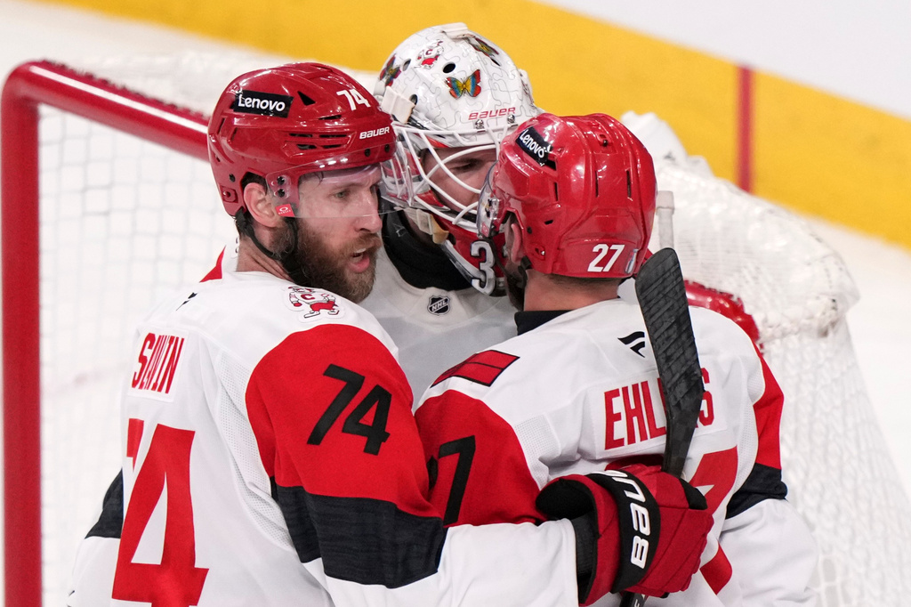 Carolina Hurricanes left wing Nikolaj Ehlers, right, celebrates his empty net goal with defenseman Jaccob Slavin, left, and goaltender Brandon Bussi during the third period in Game 4 of the NHL hockey Stanley Cup Final series against the Vegas Golden Knights, Tuesday, June 9, 2026, in Las Vegas. (AP Photo/Candice Ward)