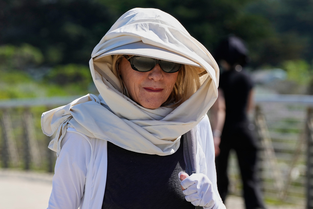 Carol Hather wears sun protective gear as she walks at Crissy Field in San Francisco, Tuesday, March 17, 2026. (AP Photo/Godofredo A. Vásquez)