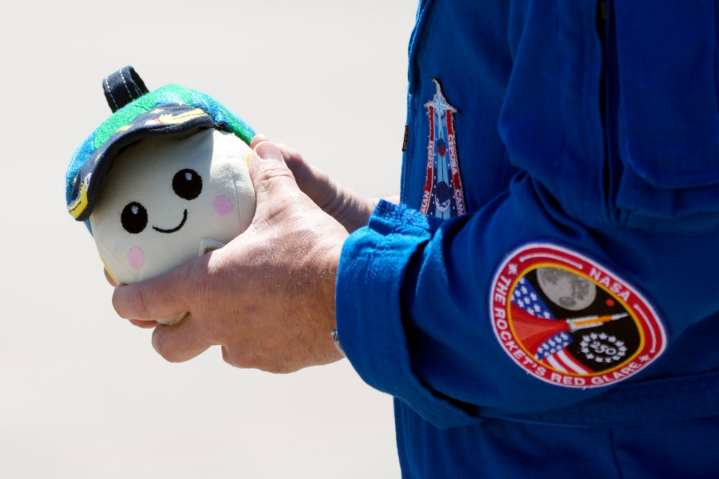 Artemis 2 crew member Commander Reid Wiseman holds "Rise" after the crew's arrival at the Kennedy Space Center Friday, March 27, 2026, in Cape Canaveral, Fla. (AP Photo/Chris O'Meara)