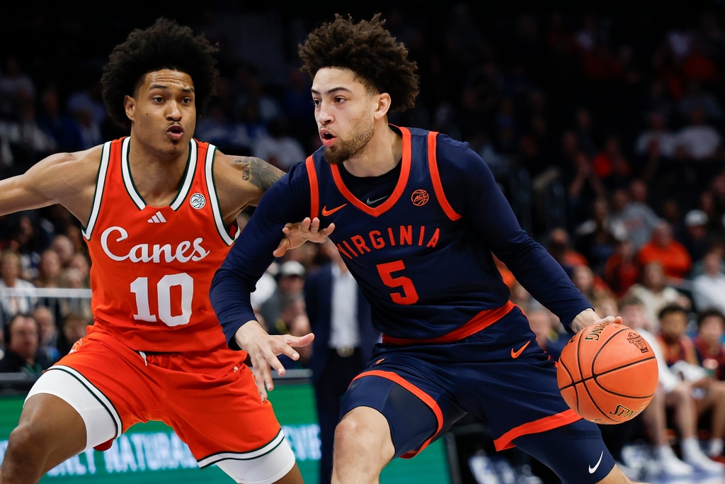 Virginia guard Sam Lewis (5) drives to the basket against Miami guard Tru Washington (10) during the first half of an NCAA college basketball game in the semifinals of the Atlantic Coast Conference tournament in Charlotte, N.C., Friday, March 13, 2026. (AP Photo/Nell Redmond)