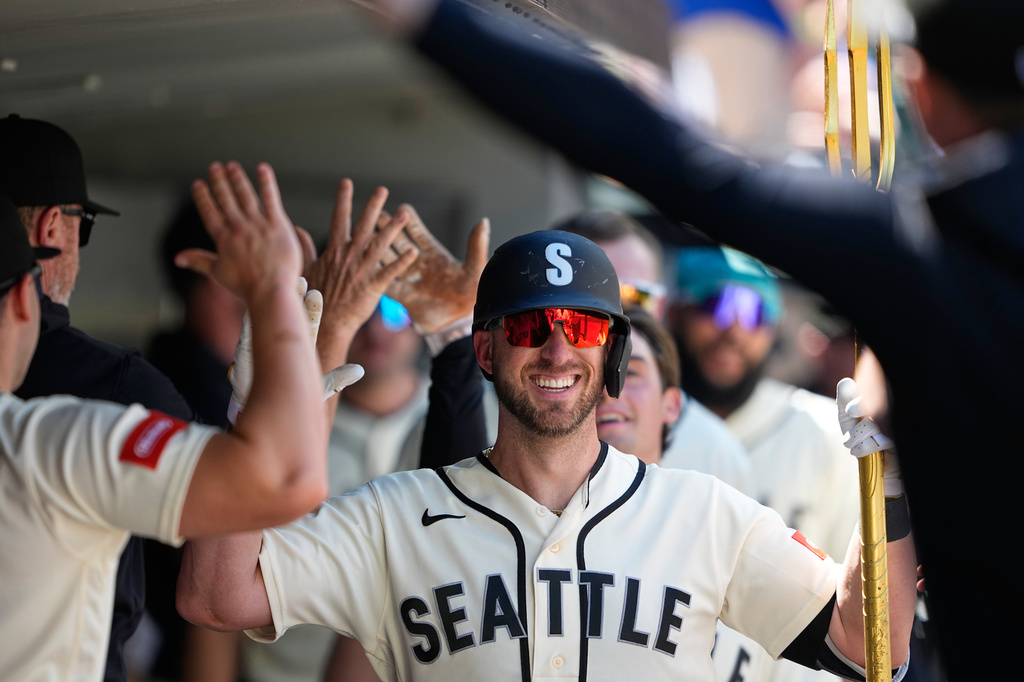 Seattle Mariners' Mitch Garver holds the trident in the dugout while celebrating his two-run home run against the Toronto Blue Jays during the fourth inning of a baseball game, Sunday, July 5, 2026, in Seattle. (AP Photo/Lindsey Wasson)