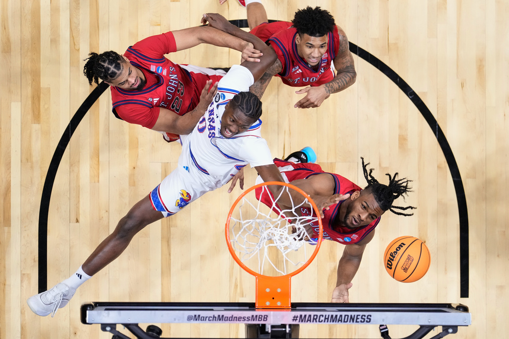 St. John's forward Zuby Ejiofor, right, and Kansas forward Flory Bidunga (40) vie for a reobund during the first half of a game in the second round of the NCAA college basketball tournament Sunday, March 22, 2026, in San Diego. (AP Photo/Mark J. Terrill)