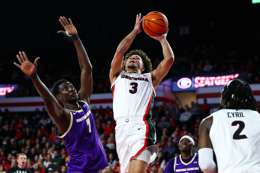 Georgia guard Jordan Ross (3) looks to shoot against Western Carolina center Abdulai Fanta Kabba, left, during the first half of an NCAA college basketball game, Thursday, Dec. 18, 2025, in Athens, Ga. (AP Photo/Colin Hubbard)